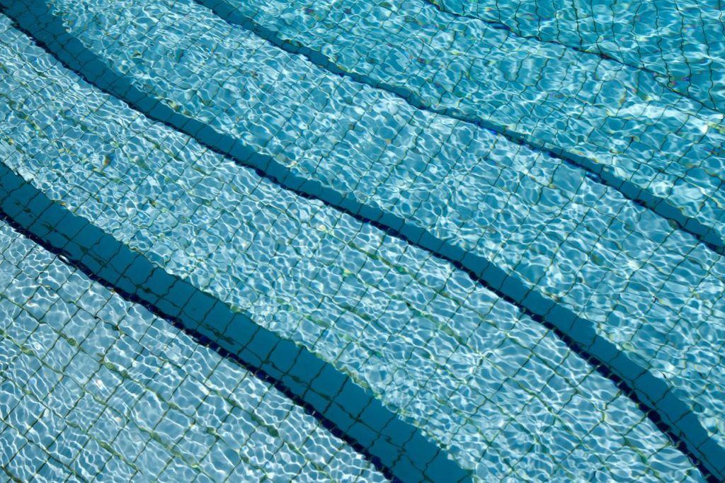 The Art of Drawing Readers In: Your attractive post title goes here A detailed view of crystal clear swimming pool water over a tiled surface, showcasing its calm and refreshing nature.
